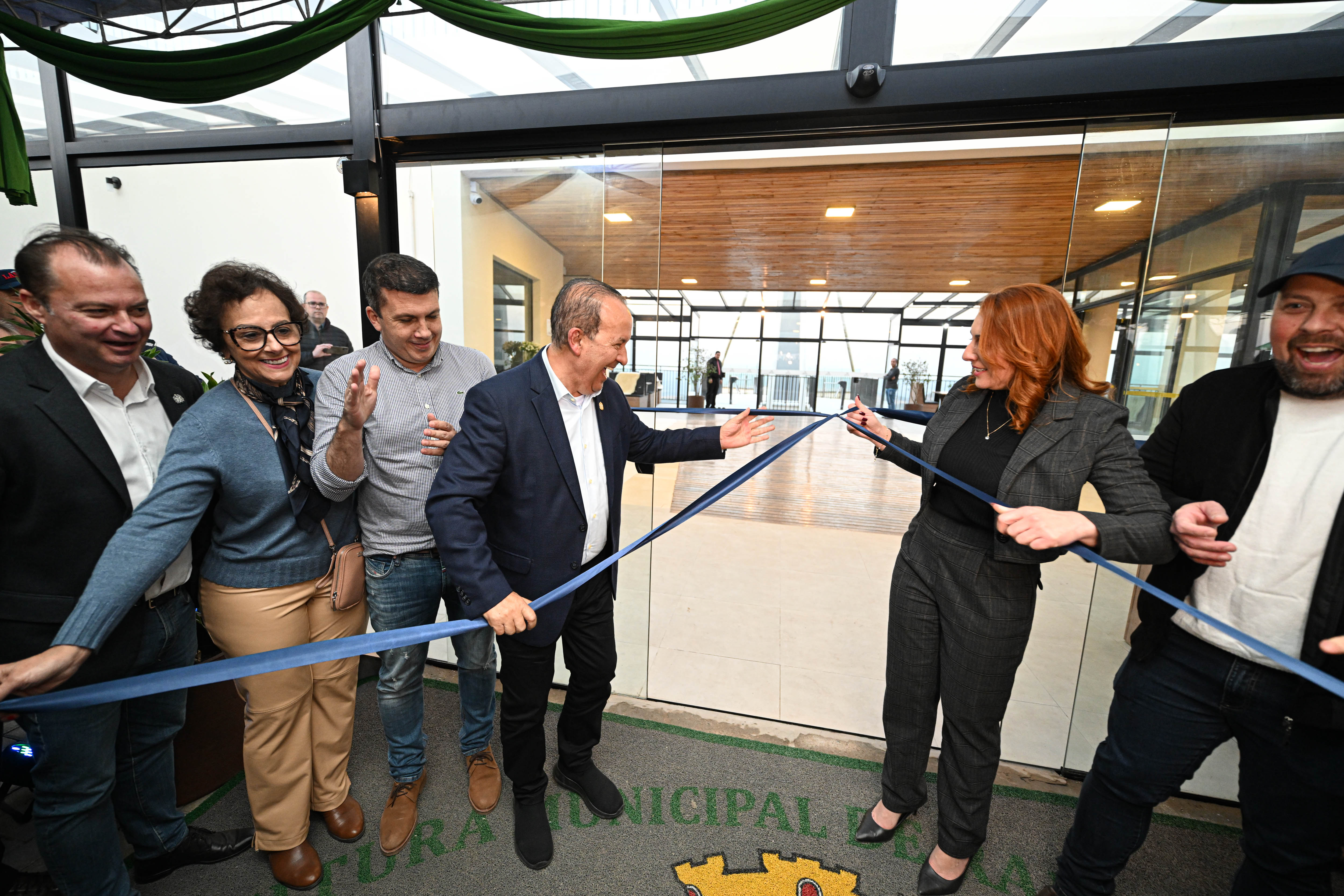 Corte da fita na inauguração do mirante, em interior envidraçado.